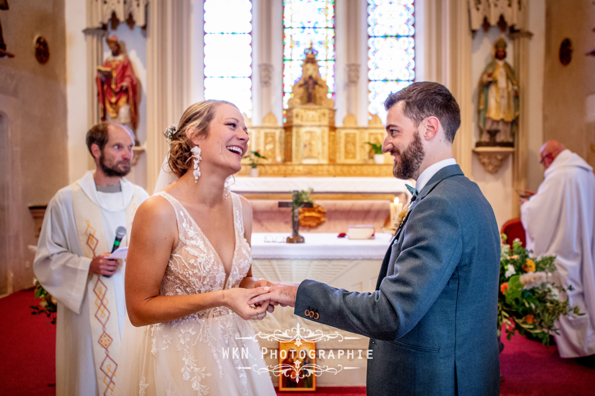 L'échange des alliances entre Claire et Corentin, sourires aux lèvres et larmes aux yeux, un moment chargé d'émotion.
